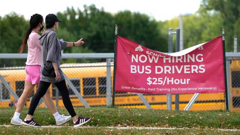 A sign advertising jobs for bus drivers is posted in...