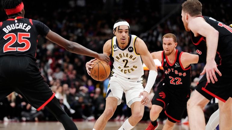 Indiana Pacers guard Andrew Nembhard (2) drives between Toronto Raptors...