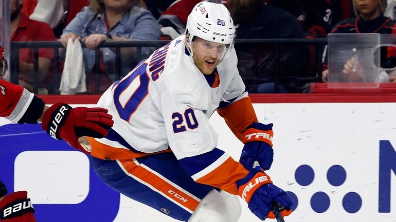 The Islanders' Hudson Fasching drives the puck past the Hurricanes' Shayne...