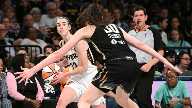 Indiana Fever guard Caitlin Clark looks to pass the ball...