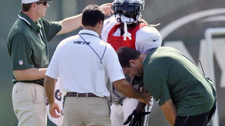 New York Jets running back Joe McKnight is helped by...