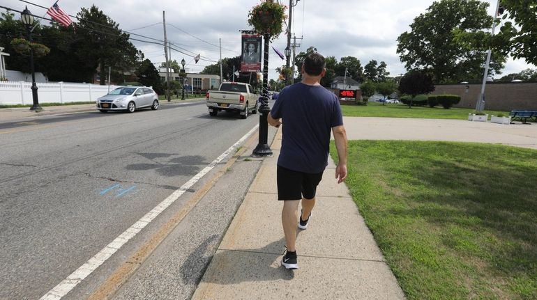 A pedestrian walks along Deer Park Avenue near North Babylon High...