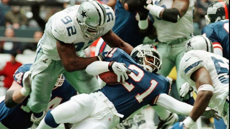 Tiki Barber stretches past Dallas Cowboys defender Tony Tolbert during...