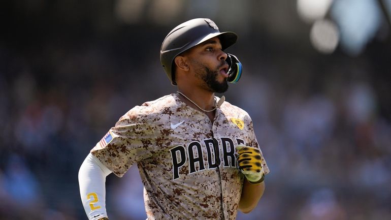 San Diego Padres' Xander Bogaerts watches as he flies out...