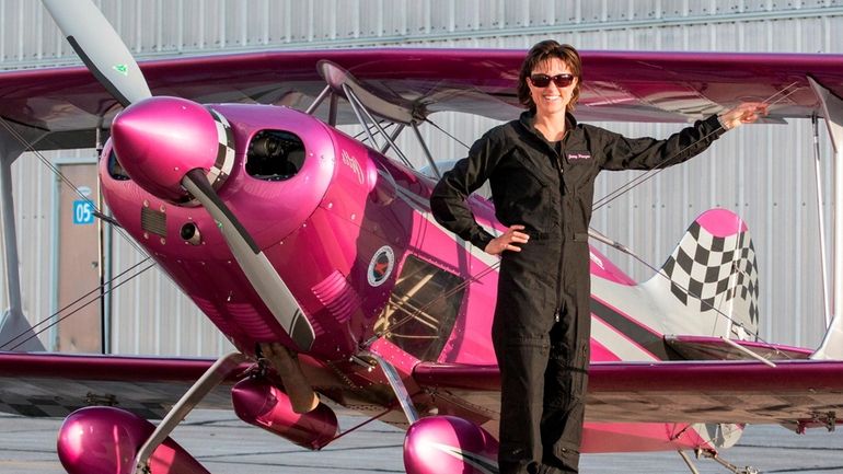 Aerobatic stunt pilot Jessy Panzer stands by a Pitts Special, an...