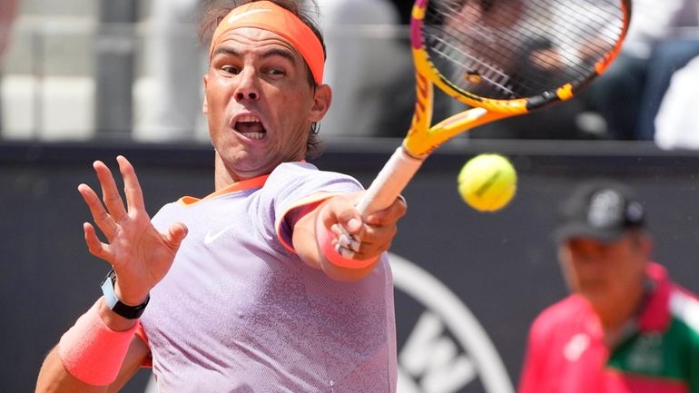 Rafael Nadal, of Spain, returns the ball to Hubert Hurkacz,...