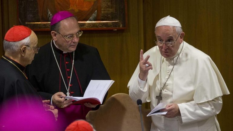 Pope Francis talks to prelates as he arrives for a...