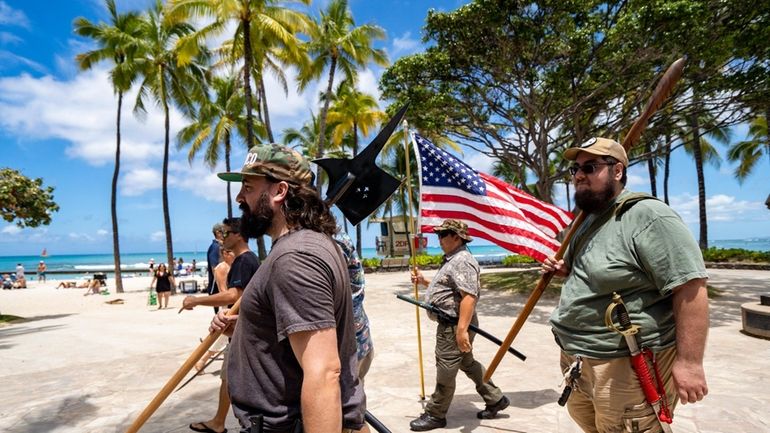 Members of Hawaii Firearms Coalition walk around Waikiki with their...