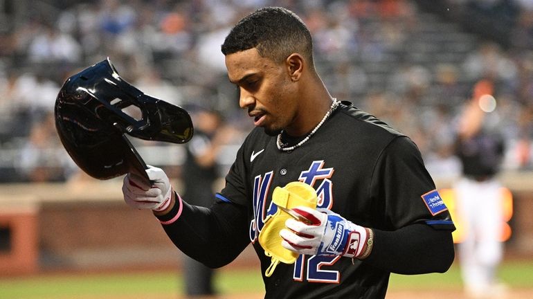 Mets shortstop Francisco Lindor returns to the dugout after he...