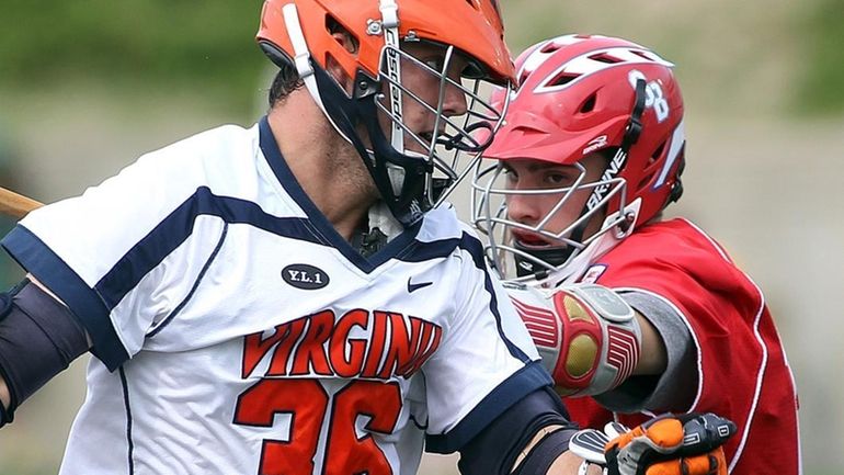 Virginia middie Brian Carroll, left, moves around Stony Brook defender...