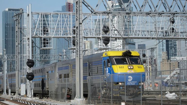 A Long Island Rail Road train passes under a new...