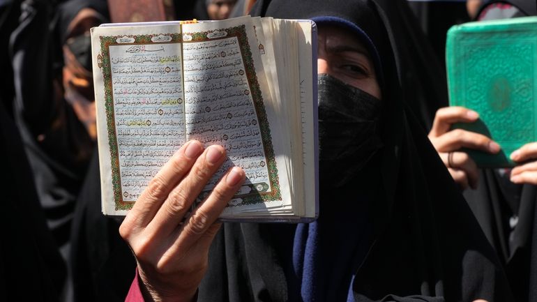 FILE -A demonstrator holds up a copy of the Quran,...