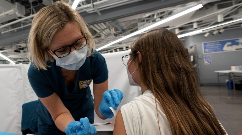 Jolanta Gawlik gives Juliana Cepeda, 20, the Pfizer vaccine on...