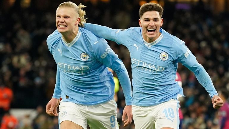 Manchester City's Julian Alvarez, right, celebrates with Manchester City's Erling...