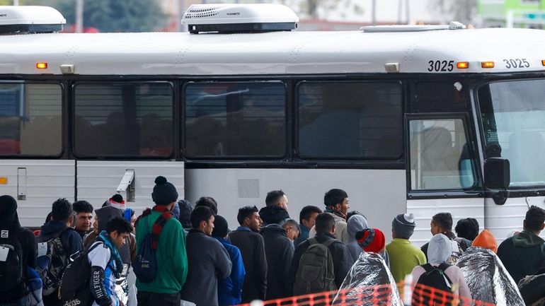 Migrants get ready to board a bus in Eagle Pass,Texas...