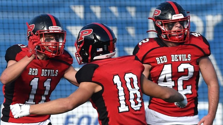 Jack Murray of Plainedge, left, gets congratulated by teammates Anthony Gentile,...