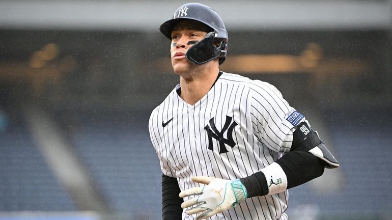 Yankees designated hitter Aaron Judge returns to the dugout after...