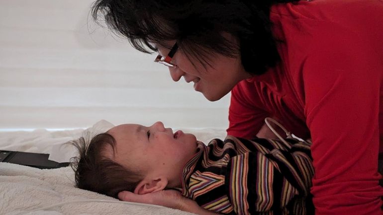 Yiwei She, 35, of Setauket, holding her son, Leo Wei...