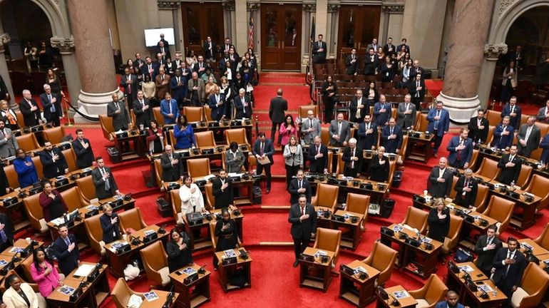 Assembly members stand for the Pledge of Allegiance in the...