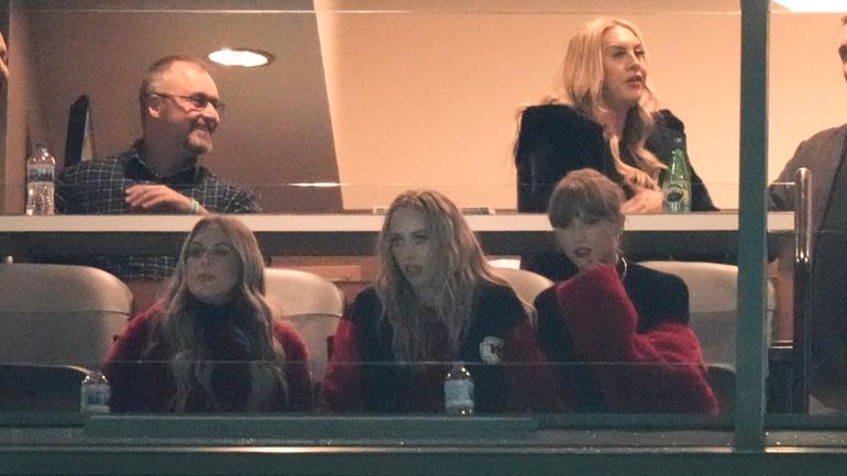 Taylor Swift, lower right, looks out on Lambeau Field during...