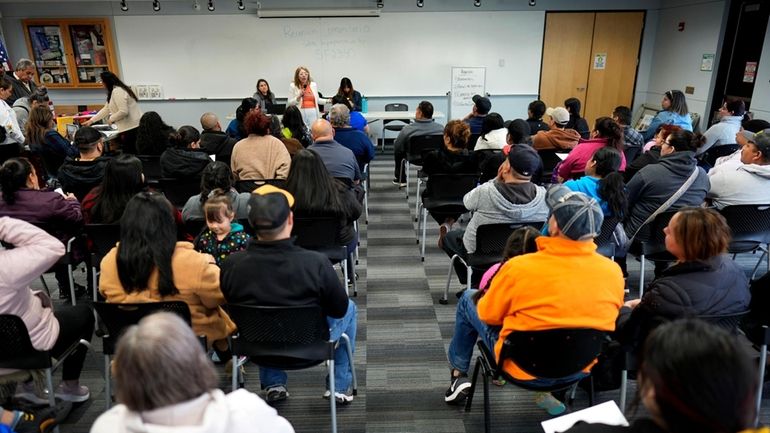 Audience members listen to community organizer Maria Acosta speak during...