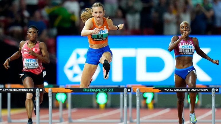 Femke Bol, of the Netherlands, center, races to win the...