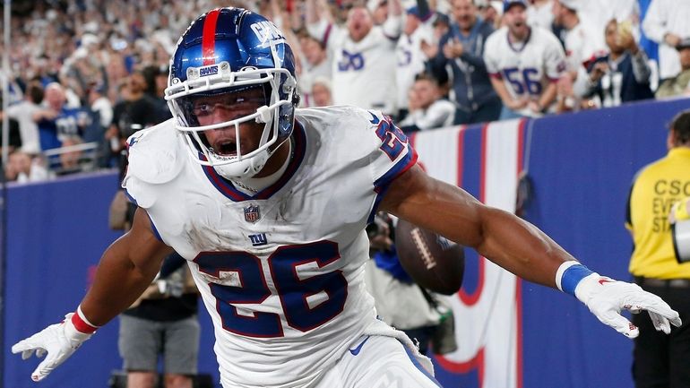 Saquon Barkley of the Giants celebrates his third-quarter touchdown run against the...