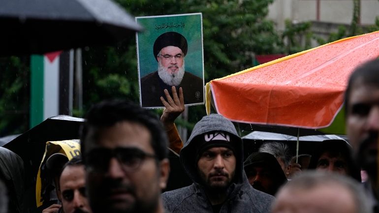 An Iranian demonstrator holds up a poster of the leader...