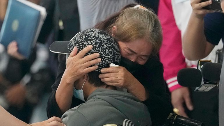 A relative hugs a Thai overseas worker who was evacuated...