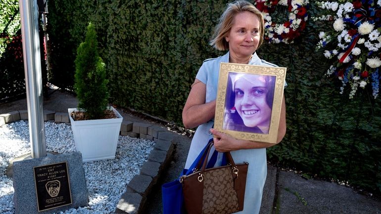 Robin Allen holds a photo of her sister, EMT Tracy Allen Lee,...