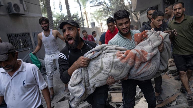 Palestinians evacuate wounded from a building destroyed in Israeli bombardment...