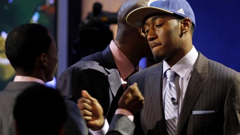 John Wall, from Kentucky, is congratulated as he walks to...