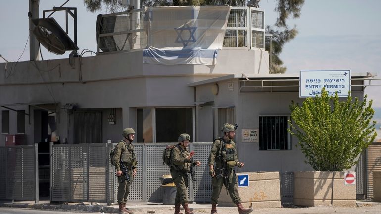 Israeli soldiers stand guard near the site of a deadly...