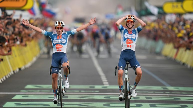 France's Romain Bardet, right, crosses the finish line with teammate...