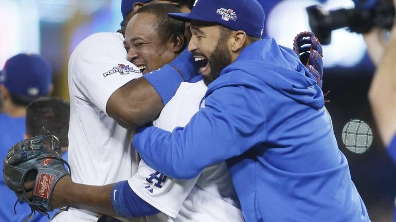 The Los Angeles Dodgers' Juan Uribe, center, is mobbed by...