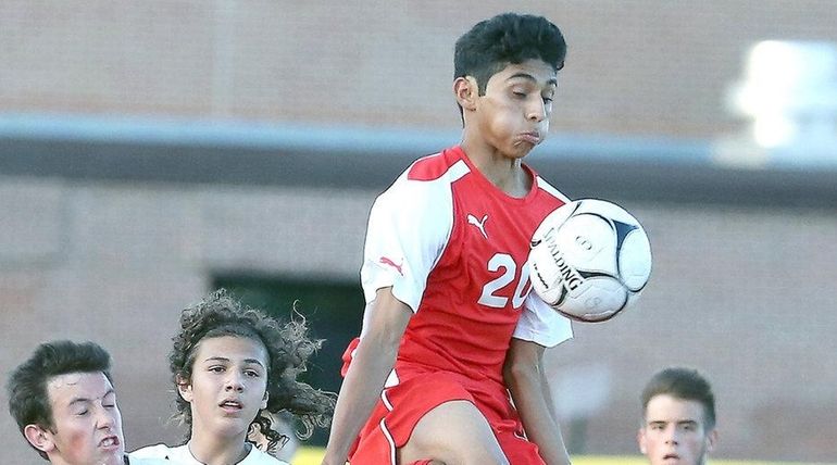 Mineola's Christian Melendez leaps high to control the ball during...