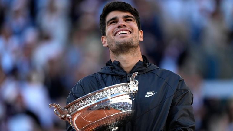 Winner Spain's Carlos Alcaraz celebrates with the trophy as he...