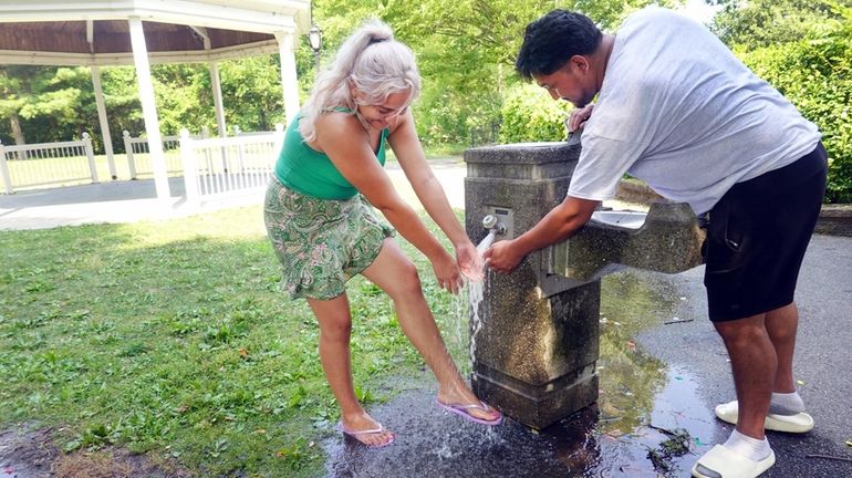 Roxy Lopez, left, and her cousin Edgar Vasquez cool off in...