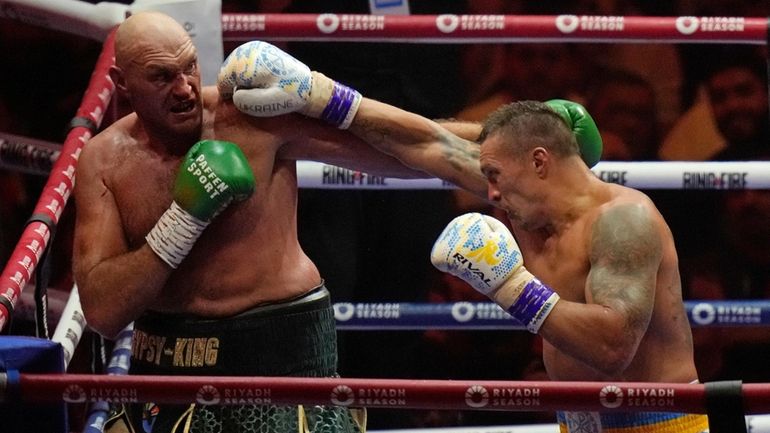 Britain's Tyson Fury, left, and Ukraine's Oleksandr Usyk trade blows...