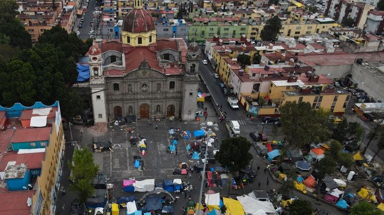 An aerial view of a migrant tent encampment set up...