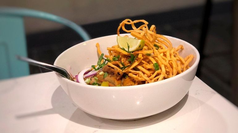 Khao soi, noodles in Thai yellow curry topped with fried...