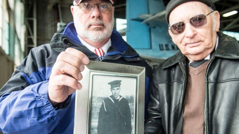 Ken Schultz and Gary Jayne hold a photo of their...