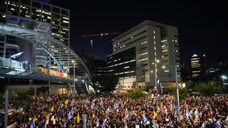 People attend a rally demanding a cease-fire deal and the...