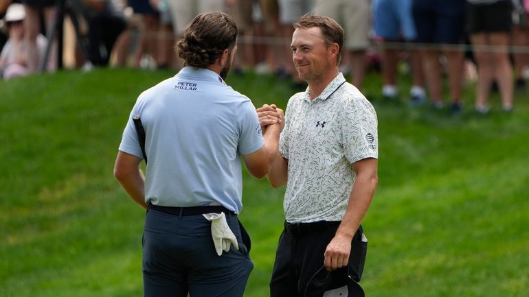 Cameron Young, left, celebrates with Jordan Spieth on the 18th...