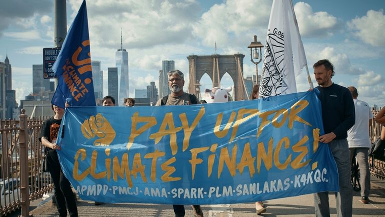 Protesters cross the Brooklyn Bridge during a Youth Climate Strike...