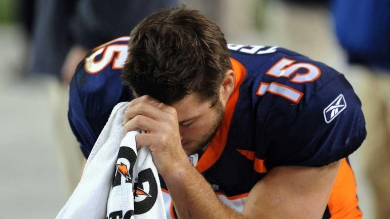 Tim Tebow of the Denver Broncos prays during the final...