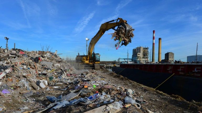 Superstorm Sandy debris being loaded into a barge that will...