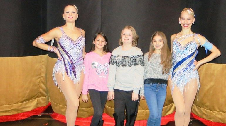 Rockettes Ashli Bear, left, and Katie Forss flank Kidsday reporters,...