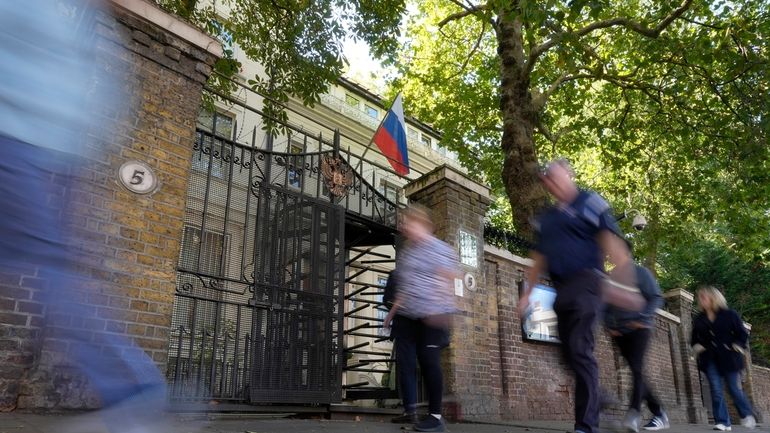 People walk past the Russian Embassy in London, Friday, Sept....