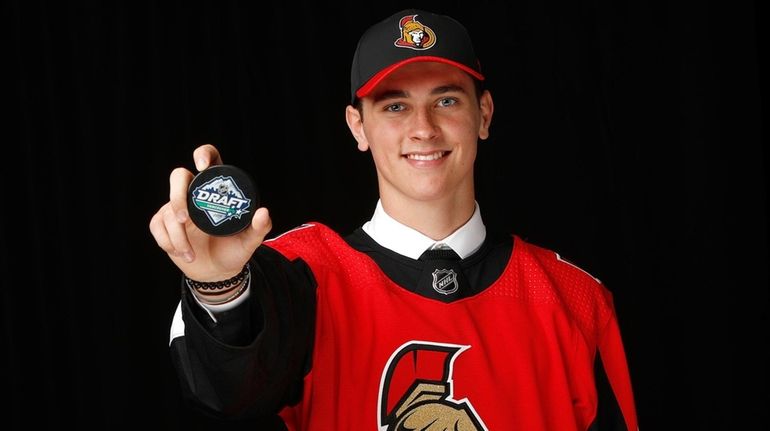 Shane Pinto poses after being selected 32nd overall by the...